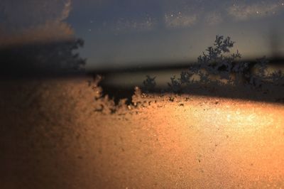 Close-up of wet sand on beach against sky