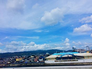 Buildings against cloudy sky