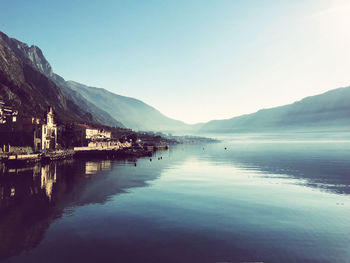 Scenic view of lake by mountains against clear sky