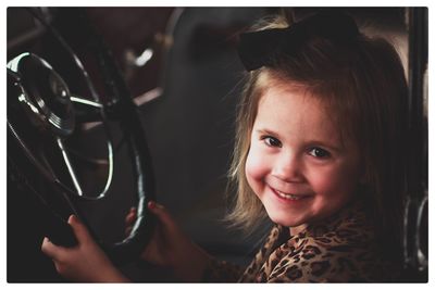 Close-up of girl smiling while sitting in car