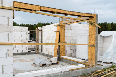 The walls of a house built of white brick with reinforced concrete pillars at the end of which 