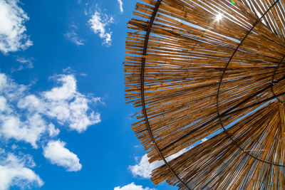 Low angle view of umbrella against blue sky