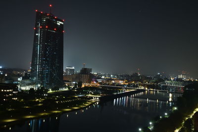 Illuminated buildings in city against sky at night