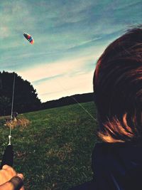 Cropped image of person holding grass in field