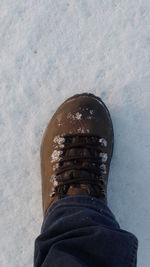 Low section of man standing in snow