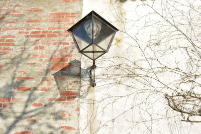 Low angle view of cross on wall against building