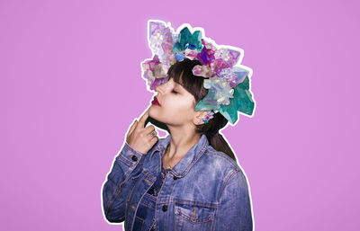 Young woman wearing headwear against pink background