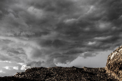 Low angle view of storm clouds over mountain