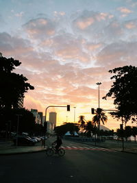 Cars parked on road at sunset