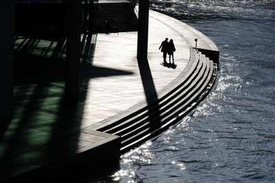 Rear view of silhouette men on water