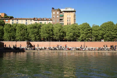 People by river against clear blue sky