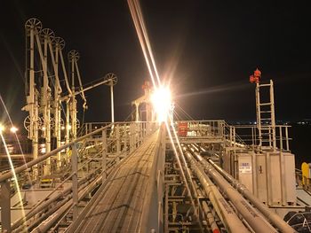 Railroad tracks against sky at night