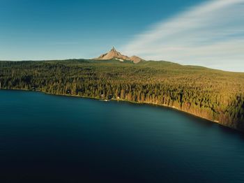 Scenic view of lake by mountain against sky