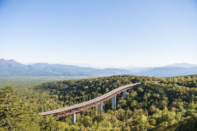 Bridge over mountains against clear sky