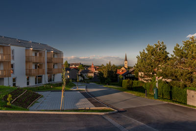 Houses by street and buildings against sky