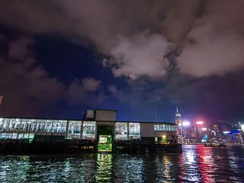 Illuminated bridge over river against sky at night