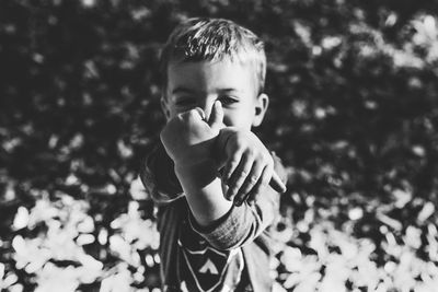 Portrait of cute boy gesturing while standing outdoors