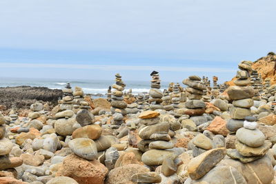 Rocks on beach against sky and pebbles
