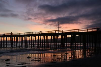 Bridge over sea against sky during sunset