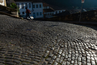 Cobblestone street by buildings in city