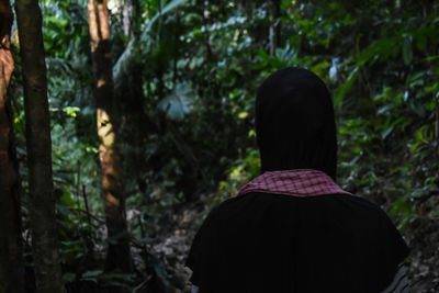 Rear view of man standing in forest