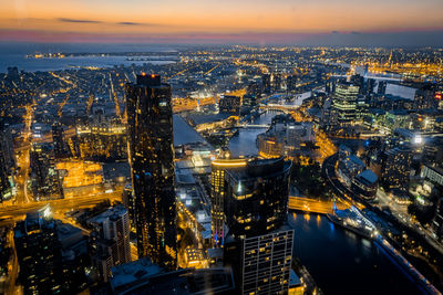 Aerial view of illuminated city at sunset