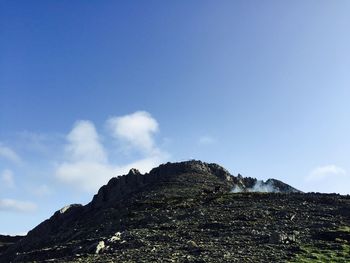 Low angle view of mountain against blue sky