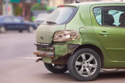 Close-up of broken car on road