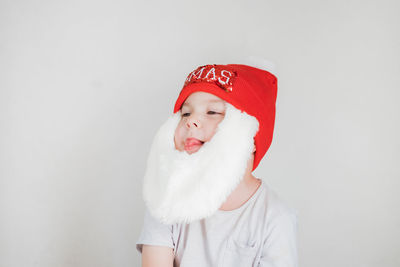 Portrait of woman wearing santa hat against white background