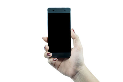 Cropped hand of woman holding mobile phone over white background