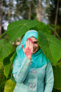 Portrait of woman standing against plants