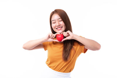 Portrait of a smiling young woman against white background