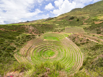 Scenic view of agricultural landscape against cloudy sky