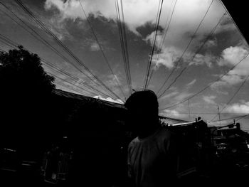 Silhouette of woman against cloudy sky