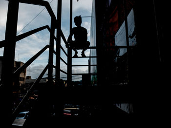 Low angle view of silhouette man on staircase against sky