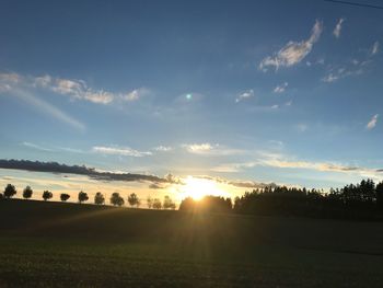 Scenic view of silhouette field against sky at sunset