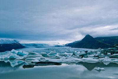 Glaciers in lake against sky