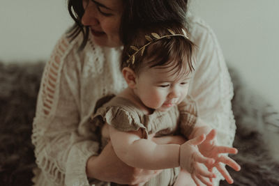 Mother holding daughter at home