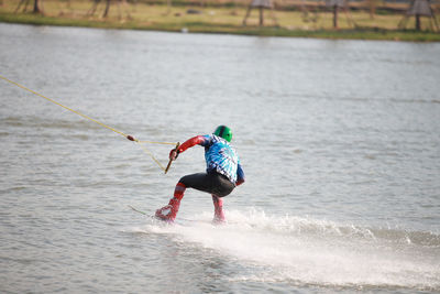 Rear view of man waterskiing in sea