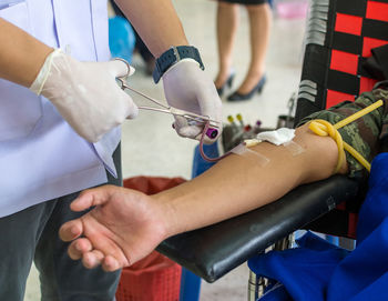 Close-up of nurse taking blood from patient in hospital