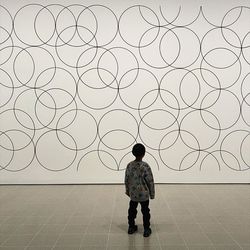 Full length rear view of boy standing against wall