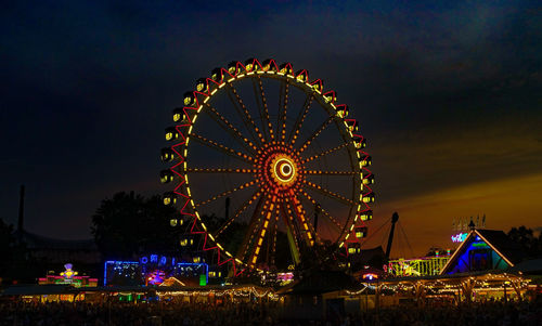 Illuminated ferris wheel against sky at night