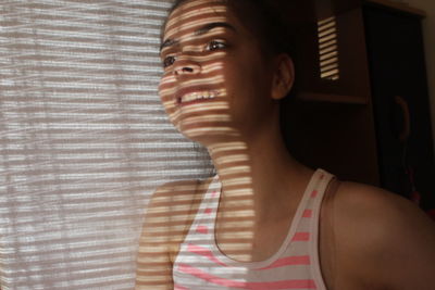 Portrait of young woman looking away at home