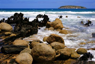 Rocks on beach against sky