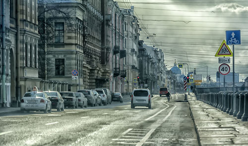 Vehicles on road amidst buildings in city