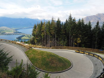 High angle view of road amidst trees against sky