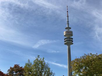 Low angle view of communications tower against cloudy sky