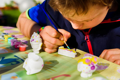 Midsection of boy holding paper bouquet on table