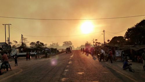 People walking on road during sunset