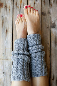 Cropped image of woman sitting on wooden wall